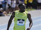 Jamajský sprinter Usain Bolt kontroluje asomíru po dobhu závodu na 200 metr.