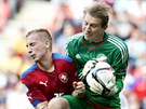 eský fotbalista Jan Baránek atakuje dánského brankáe Jakoba Buska Jensena.