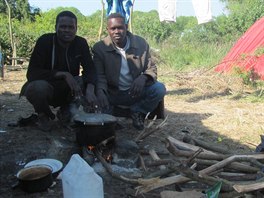 Večery tráví běženci ze Súdánu společně, skromnou večeři si vaří v kotlíku mezi...
