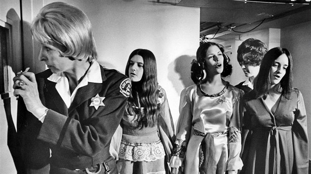 Vraždící hippies při zpěvu:  zleva Patricia Krenwinkle, Leslie Van Houtonová a Susan Atkinsová při eskortě.