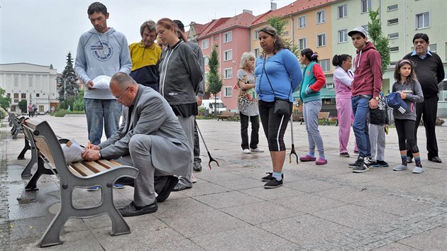 Starosta Bohumna Petr Vcha podepisuje pevzet petice od lid z tamnch ubytoven. (15. ervna 2015)