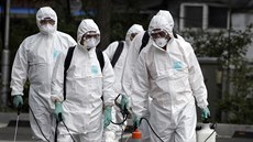 Pracovníci v ochranných oblecích provádjí dezinfekci v jihokorejském Soulu...