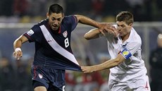 Clint Dempsey (vlevo) z USA uniká Stevenu Gerrardovi z Anglie