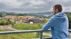 Luká� Hvojník shlí�í ze svého balkonu na místo, kde by m�la stavba vyr�st.
