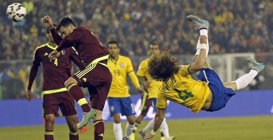 Brazilský fotbalista David Luiz pi akrobatickém steleckém pokusu v zápase s...