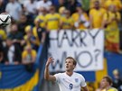 Anglický útočník Harry Kane a na pozadí posměšný transparent švédských fanoušků