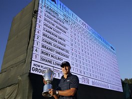 Americk golfista Jordan Spieth pzuje s trofej ped vsledkovou tabul US...