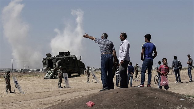 Lid stojc na tureck stran hranic sleduj dn v syrskm Kobani (27. ervna 2015).