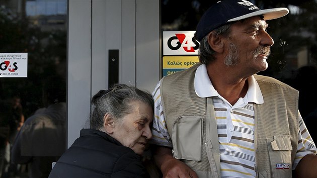 Pětasedmdesátiletá aténská důchodkyně Vallia (vlevo) drží dveře pobočky řecké Národní banky. Stejně jako další penzisté doufá, že se domůže svého důchodu. (29. 6. 2015)