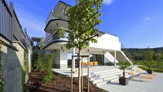 Z terasy v pzem vede, jako socha dotvejc eleganci domu, dominantn pohodln schodit sestupujc na terasu s baznem. Propojuje dm s kultivovan pojednanou zahradou.