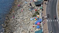 Ležení migrantů na pláži ve městě Ventimiglia na hranicích Itálie a Francie...