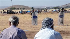 Turetí vojáci steí hranice se Sýrií, v pozadí jsou lidí z Kobani, kteí...