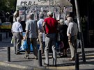 Lidé si u kiosku v centru Atén proítají novinové titulky. (30. 6. 2015)