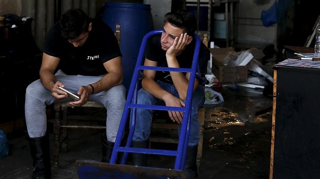 Mladíci odpočívají u hlavního vchodu do aténské rybí tržnice. (30. 6. 2015)