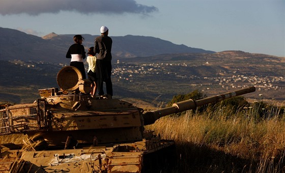 Drúzové z Golanských výin sledují z izraleského tanku boje v drúzské vesnici...