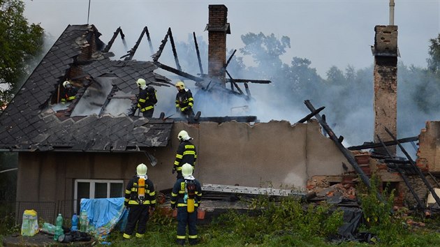 Hasiči dohašují rodinný dům v Hodoníně na Chrudimsku, který zasáhl blesk. Hasiči z plamenů zachránili psa. (8. 7. 2015)