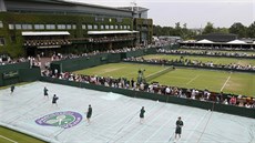 PLACHTY DOL. Poadatelé odkrývají ve Wimbledonu kurty, ve tvrtek prelo.