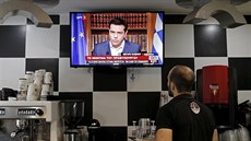 íník v kavárn v Aténách sleduje projev eckého premiéra Tsiprase, ve kterém...