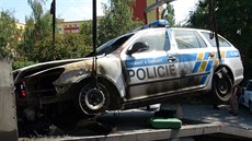Podpálené policejní auto u sluebny v Praze-Stranicích (1. ervence 2015).