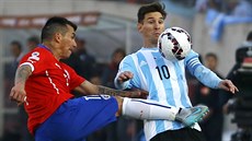 Chilský fotbalista Gary Medel na  argentinského útočníka Lionela Messiho během...