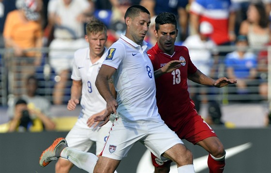 Americký útoník Clint Dempsey stílí pes bránícího Jorge Luise Corralese...