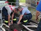 Hasii oderpávají vodu ze zatopeného stavenit v Praze-Michli. (12.7.2015)