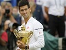 Novak Djokovi hrd pózuje s trofejí pro vítze Wimbledonu.