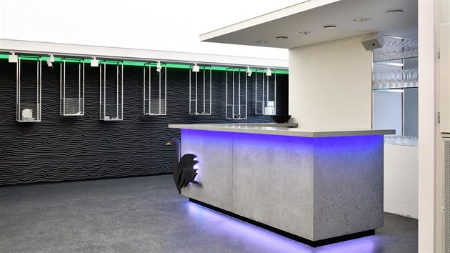 Dominantu prostoru  tvoří podsvícený barový pult s betonovými obklady s výraznou strukturou a plastikou černé labutě z ultra černého betonu.
