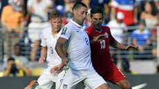 Americký úto�ník Clint Dempsey st�ílí p�es bránícího Jorge Luise Corralese...