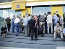 Klienti čekají na otevření Piraeus Bank v Heraklionu na Krétě (20. července...