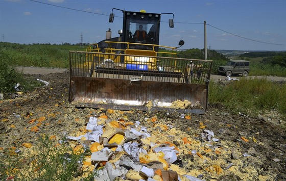 Buldozer zahrnuje sýr na skládce v Belgorodské oblasti.