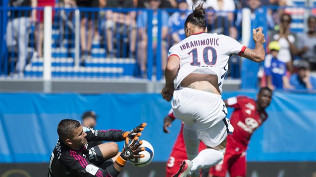 Lyonsk brank Anthony Lopes zasahuje ped Ziatanem Ibrahimovicem z Paris SG.