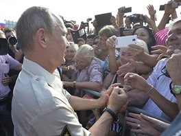 Vladimir Putin se zdrav s lidmi.