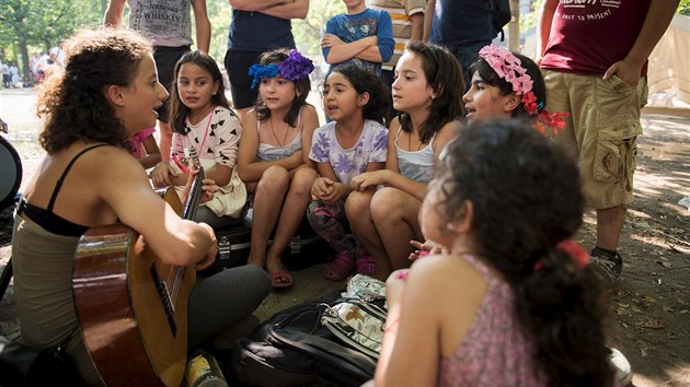 Němečtí dobrovolníci zpívají s malými uprchlíky v Berlíně (10. srpna 2015)