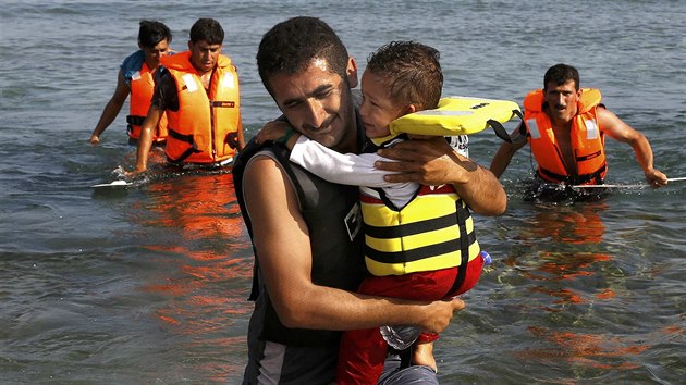 Uprchlk z rnu se synem prv pipluli pes Turecko na eck ostrov Kos (15. srpna 2015).
An Iranian migrant cries while carrying his son as a small group of exhausted Iranian migrants arrive by paddling an engineless dinghy on the Greek island of Kos
