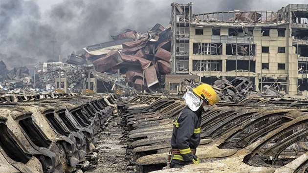 Hasi kontroluje znien auta po steden explozi v nskm mst Tchien-in (15. srpna 2015).