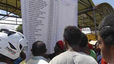 Lidé si �tou seznam cestujících z havarovaného letu spole�nosti Trigana Air....