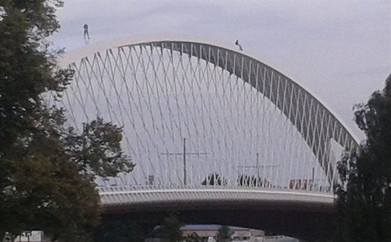 Po oblouku Trojského mostu se procházeli dva lidé.