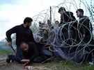 Uprchlíci pekonávají erstv zbudovaný plot na hranicích Maarska a Srbska...
