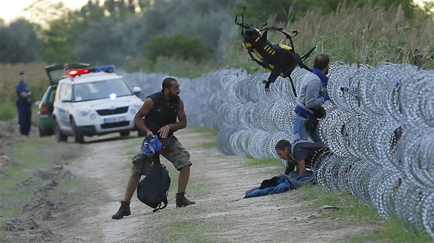 Uprchlci pekonvaj erstv zbudovan plot na hranicch Maarska a Srbska (25. srpna 2015)