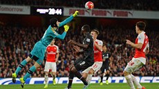 Branká� Petr �ech z Arsenalu vyrá�í mí� p�ed  Christianem Bentekem z Liverpoolu.