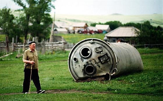 Rázovitá ruská vesnika a za humny se válí torzo z rakety vyputní z...