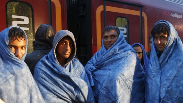 Vyerpan uprchlci se zahvaj na ndra v rakouskm mst Nickelsdorf. Vlaky je odvezou do Nmecka (5. z 2015).