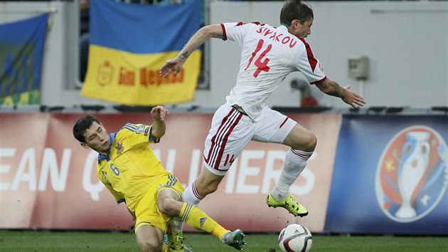 Ukrajinsk fotbalista Stpannko v souboji o m s Blorusem Sivakovem bhem kvalifikanho duelu o Euro 2016.