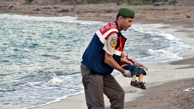 Turecký policista nese tělo malého chlapce, kterého vyplavilo moře u pobřežního města Bodrum. Loď se skupinou syrských migrantů se potopila cestou na řecký ostrov Kos. (2. září 2015)