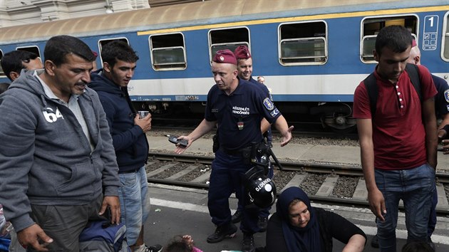 Policista se sna organizovat uprchlky, kte se usadili na nstupiti budapeskho ndra Keleti. (3. z 2015)