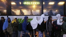 Uprchlíci v rakouském mst Nickelsdorf se adí u policejního autobusu (5. záí...