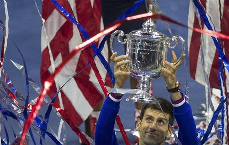 OSLAVA VÍTZE. Novak Djokovi s pohárem pro vítze tenisového US Open v záplav...