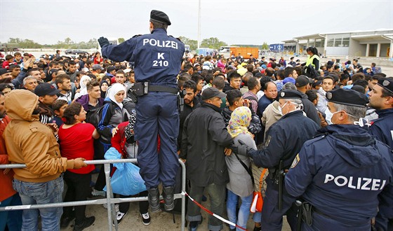 Rakoutí policisté se snaí zklidnit dav migrant u msta Nickelsdorf nedaleko...