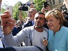 Uprchlíci v Berlín vítali kancléku Angelu Merkelovou s nadením. (10. záí...